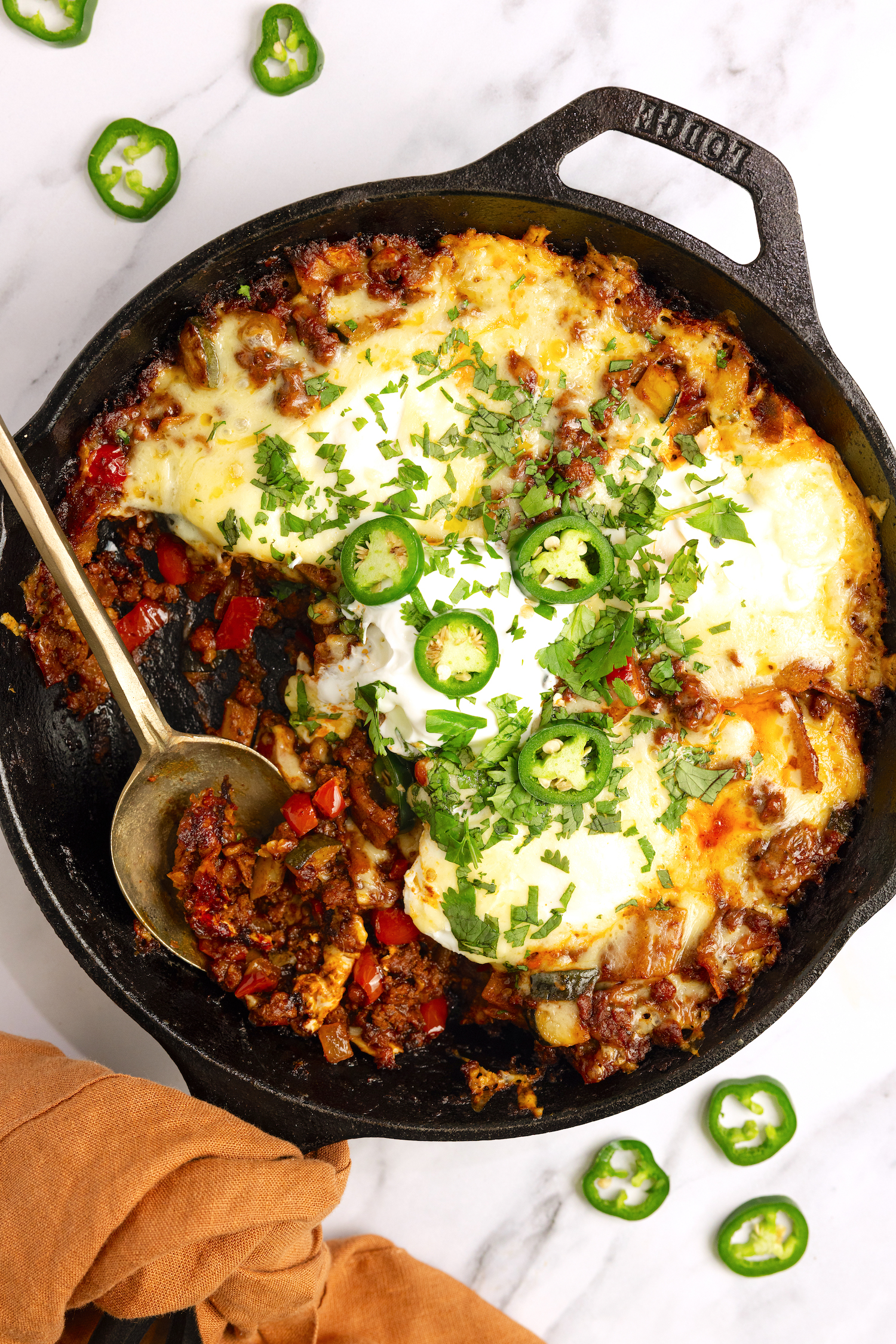 skillet filled with delicious enchilada and cheese topping